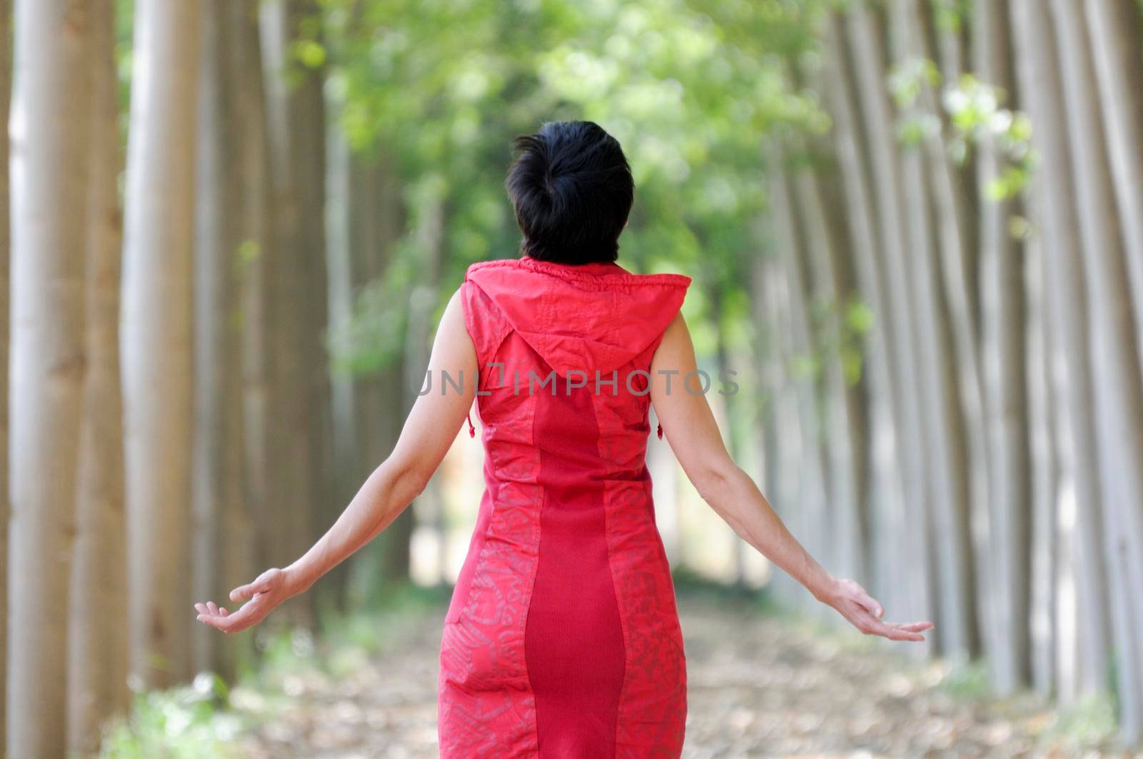 Woman dressed in red, meditating in the forest