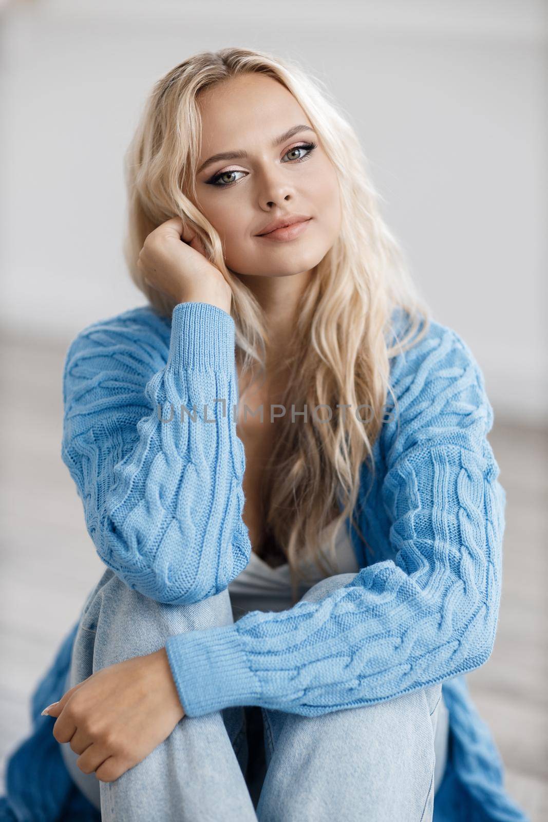 Young beautiful blond woman portrait indoor by splash