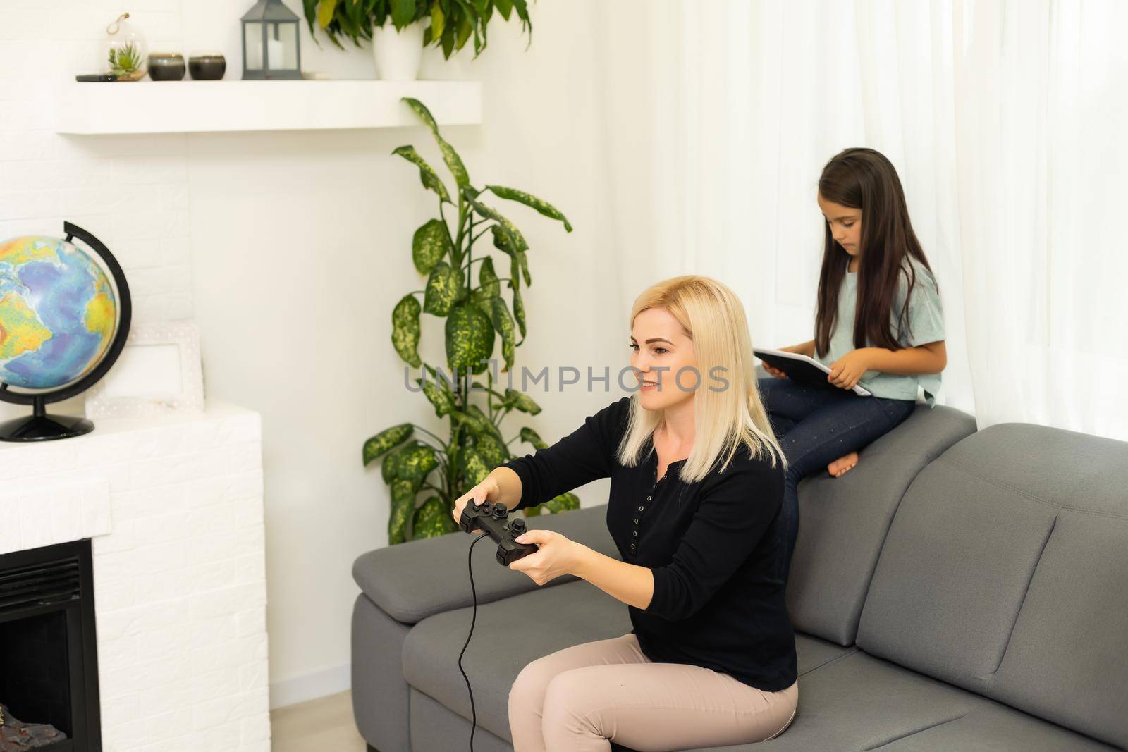 happy family together. mother and her child girl playing video games. family relax.