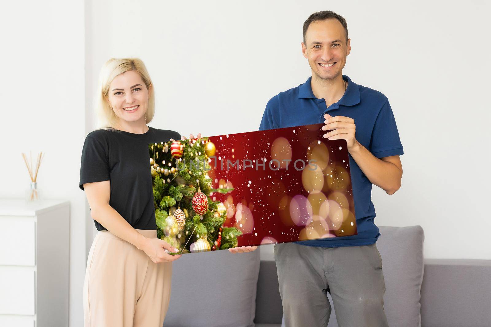 family holding photo canvas with christmas picture.