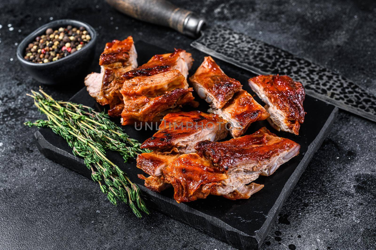 Sliced Grilled veal short spare rib meat with butcher knife. Black background. Top view by Composter