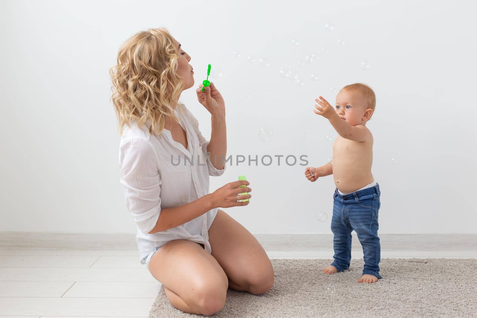 Family and childhood concept - Portrait of mother and baby playing and smiling at home