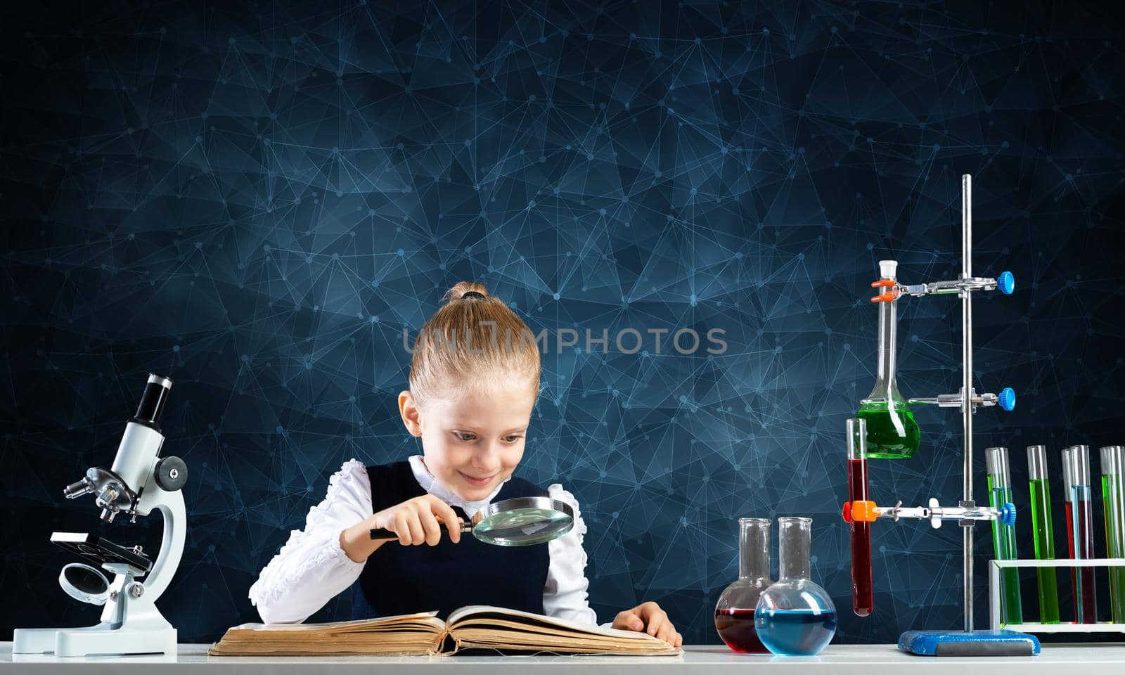 Little girl sitting at desk with magnifier and open book. Research and education in school. Happy schoolgirl in school wear carefully studying book. Clever girl reading book with magnifying glass.