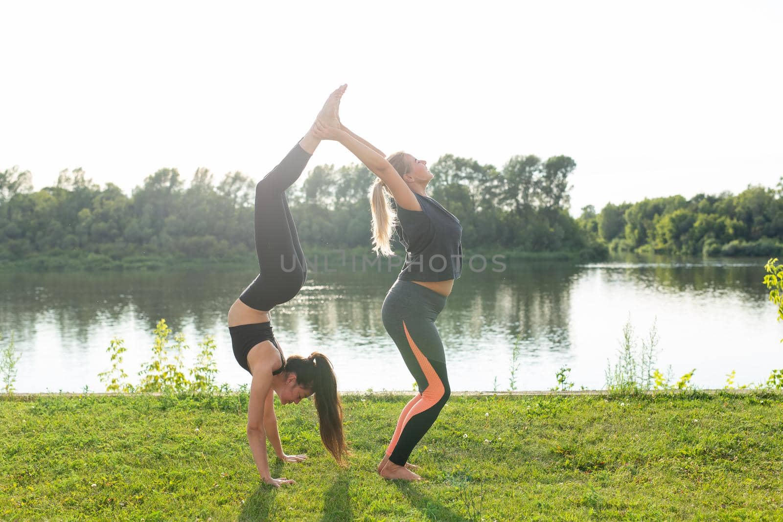 Female friends enjoying relaxing yoga outdoors in the park