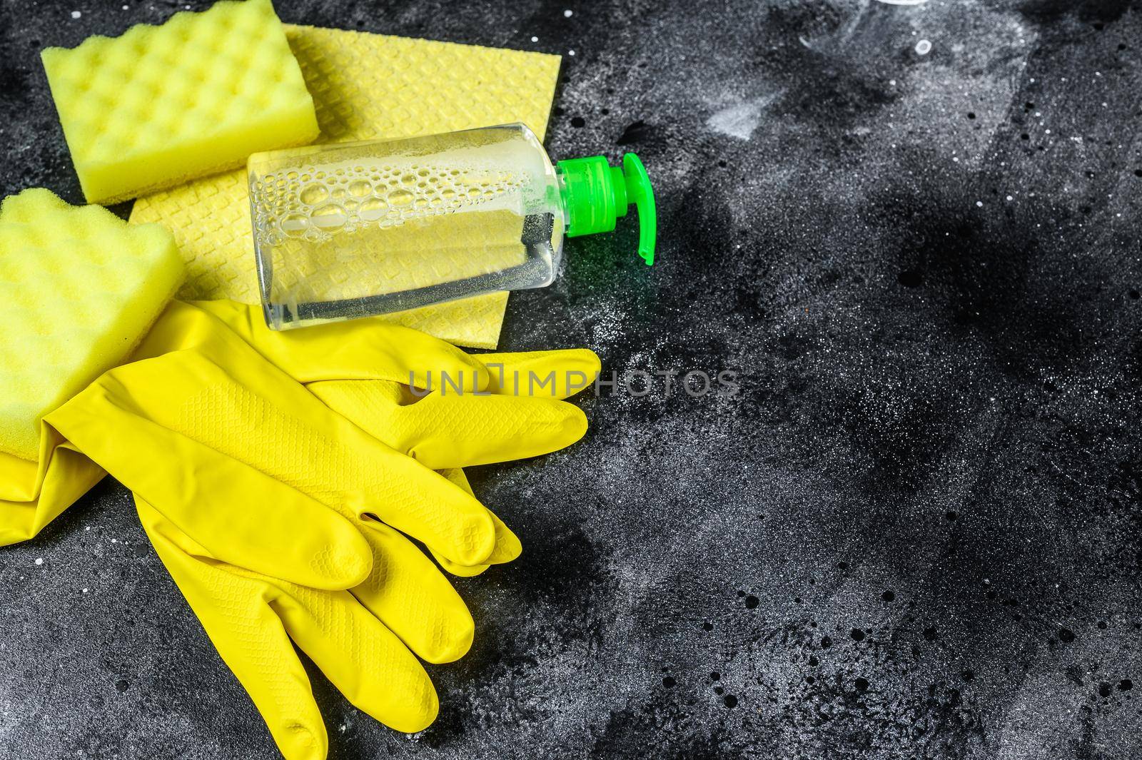 Kitchen yellow cleaning concept, housecleaning, hygiene, spring, chores, cleaning supplies. Black background. Top view. Copy space.