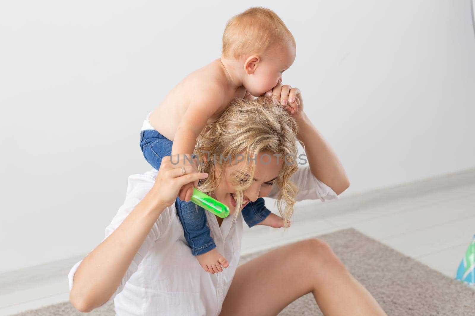 Family and childhood concept - Portrait of mother and baby playing and smiling at home