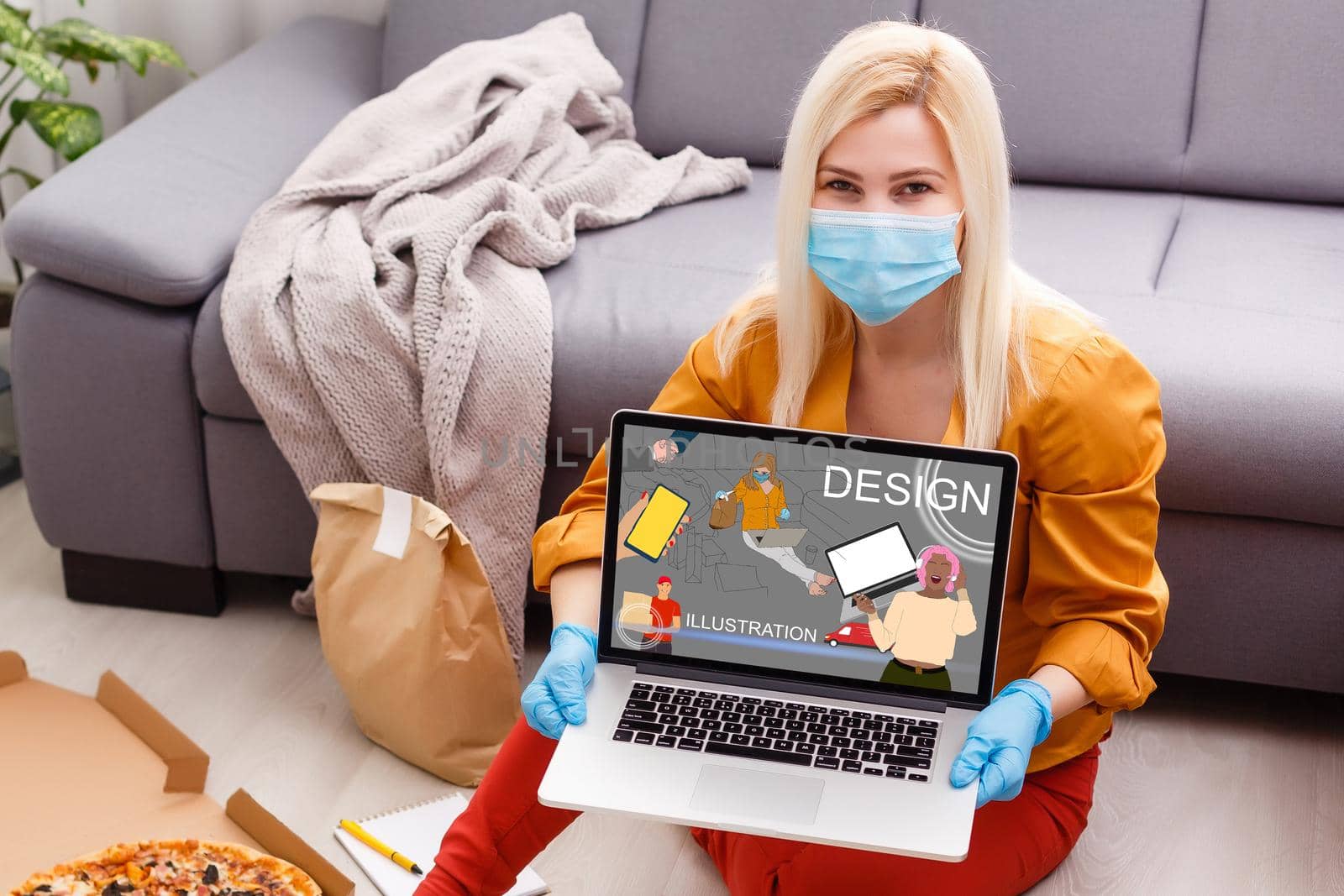 Freelance. A young woman is working at a computer in rubber gloves, and removing the medical mask from her face, looks up. Home decor. The concept of quarantine, self-isolation and remote work