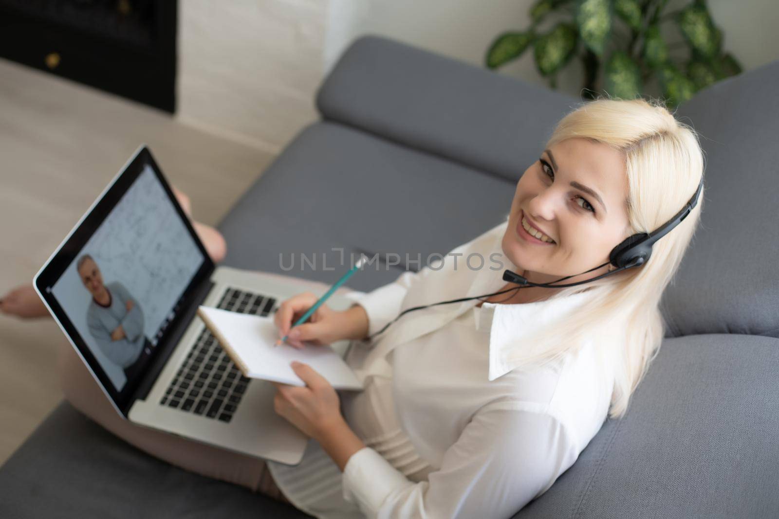 Woman using laptop indoor. woman listens to online lecture by Andelov13
