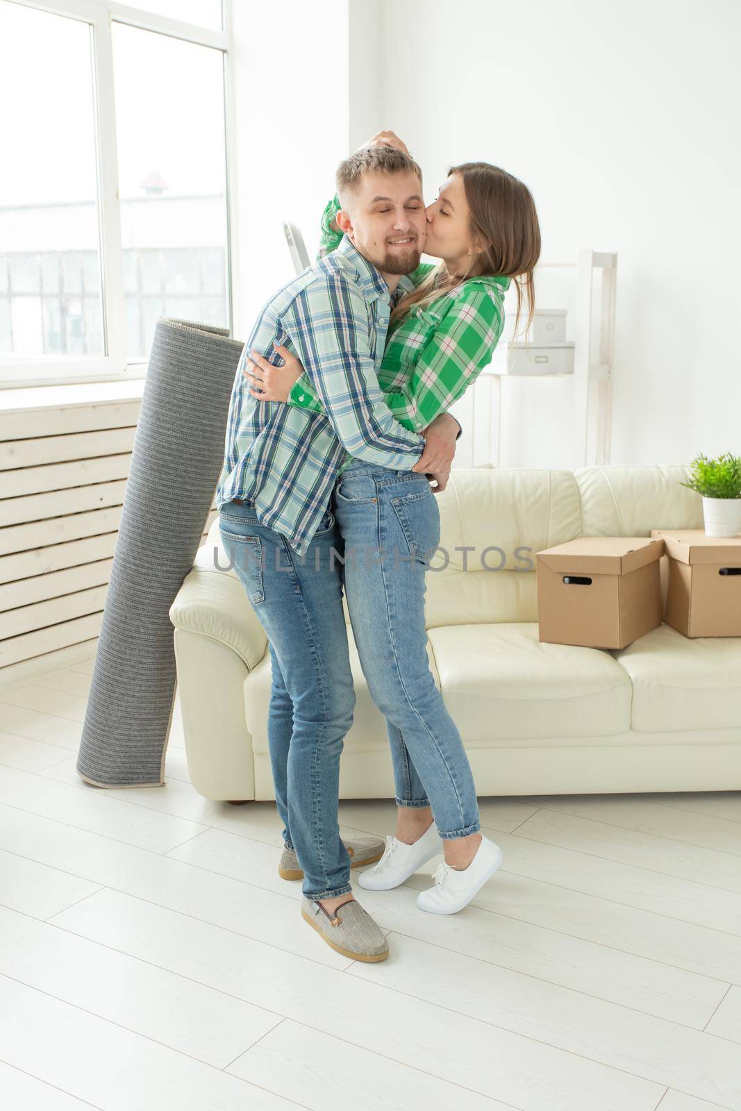 Loving young couple embracing rejoicing in moving to their new home. The concept of moving and housewarming of young family