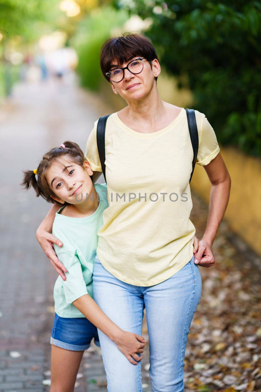 Middle-aged mother and daughter standing on the street by javiindy