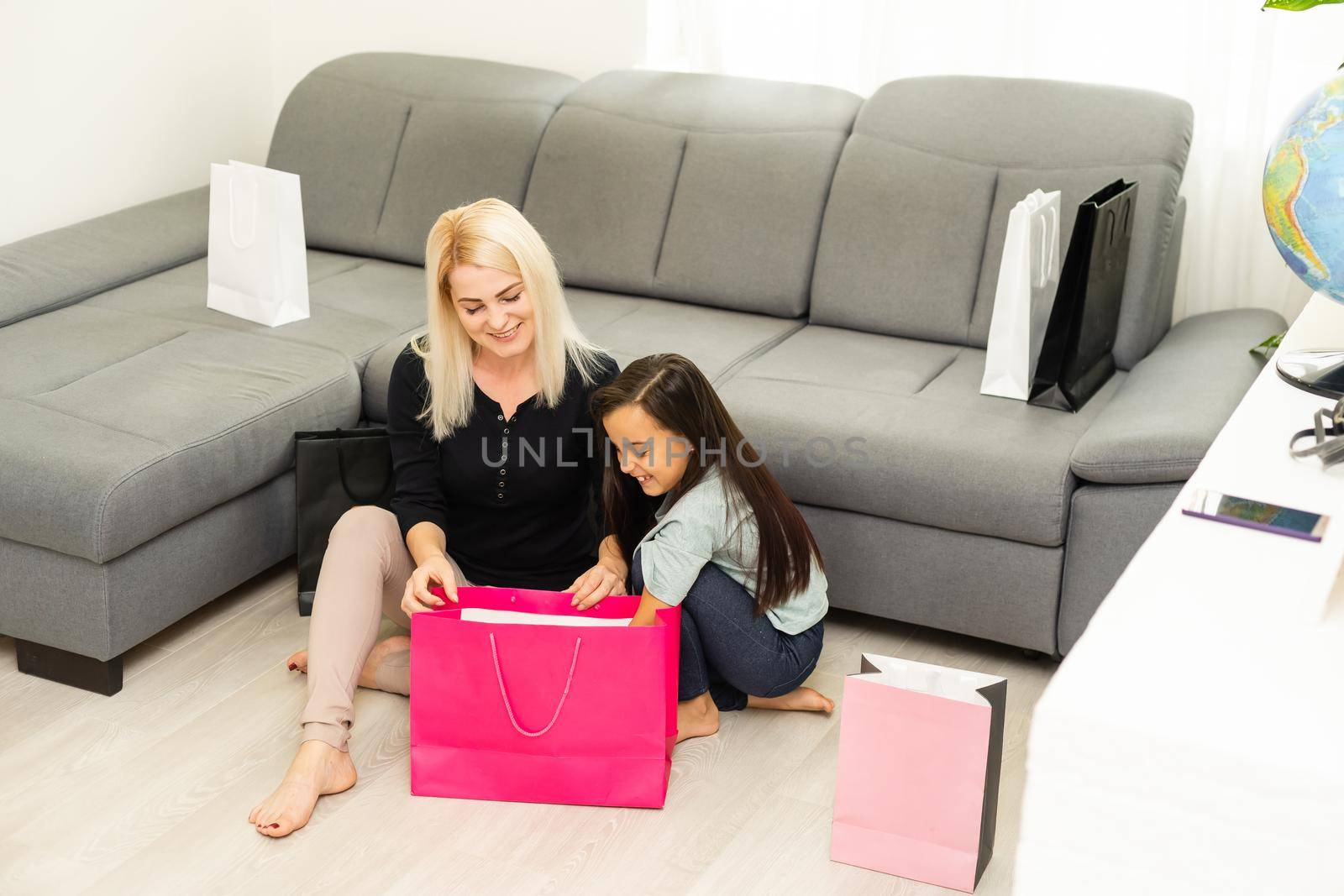 holidays, presents, christmas, x-mas, birthday concept - happy mother and child girl with gift bags