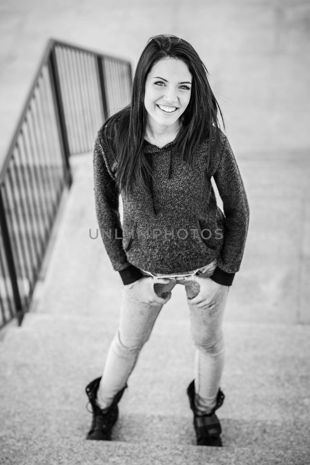 Portrait of brunette young woman with green eyes, wearing casual clothes, in urban background