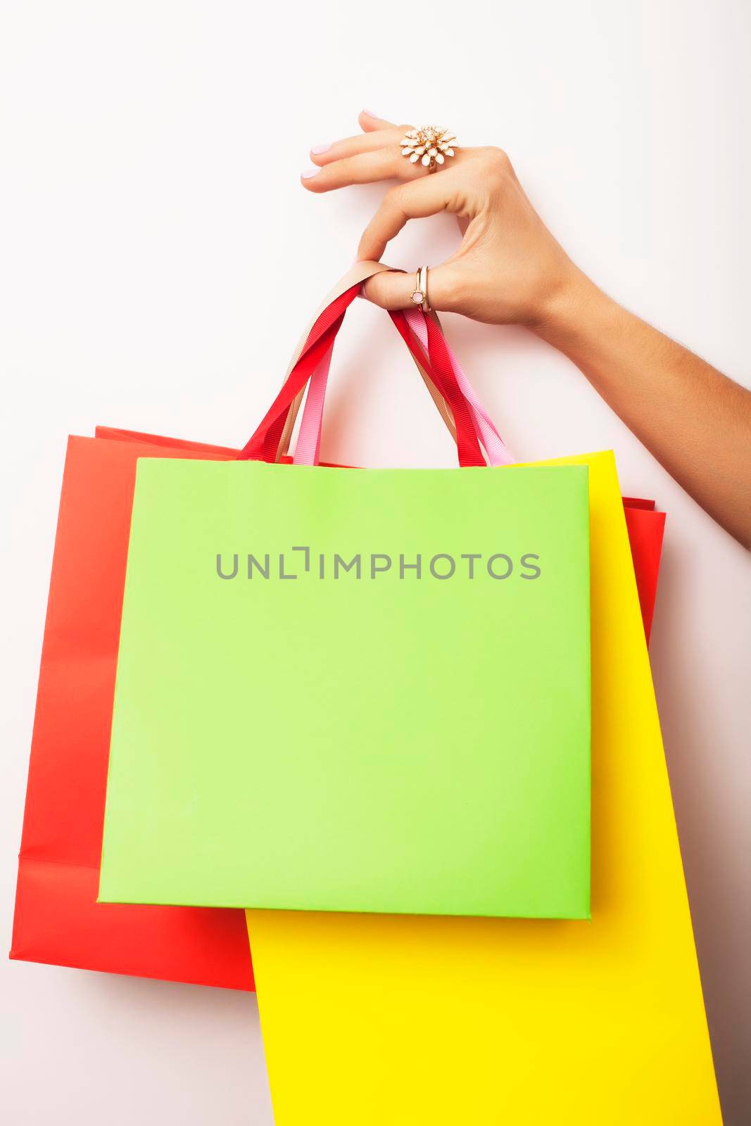 woman hand holding few paper bags on white background isolated, shopping sale concept close up