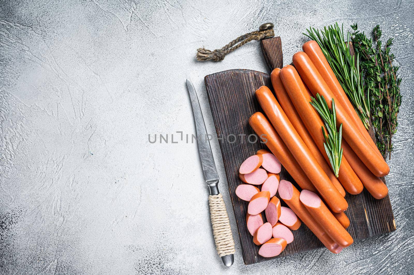 German raw Frankfurter sausages on a wooden board. White background. Top view. Copy space.