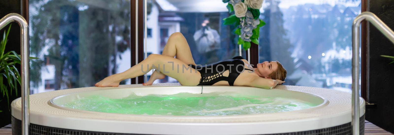 Pretty young woman relaxing in the whirlpool bathtub by Andelov13