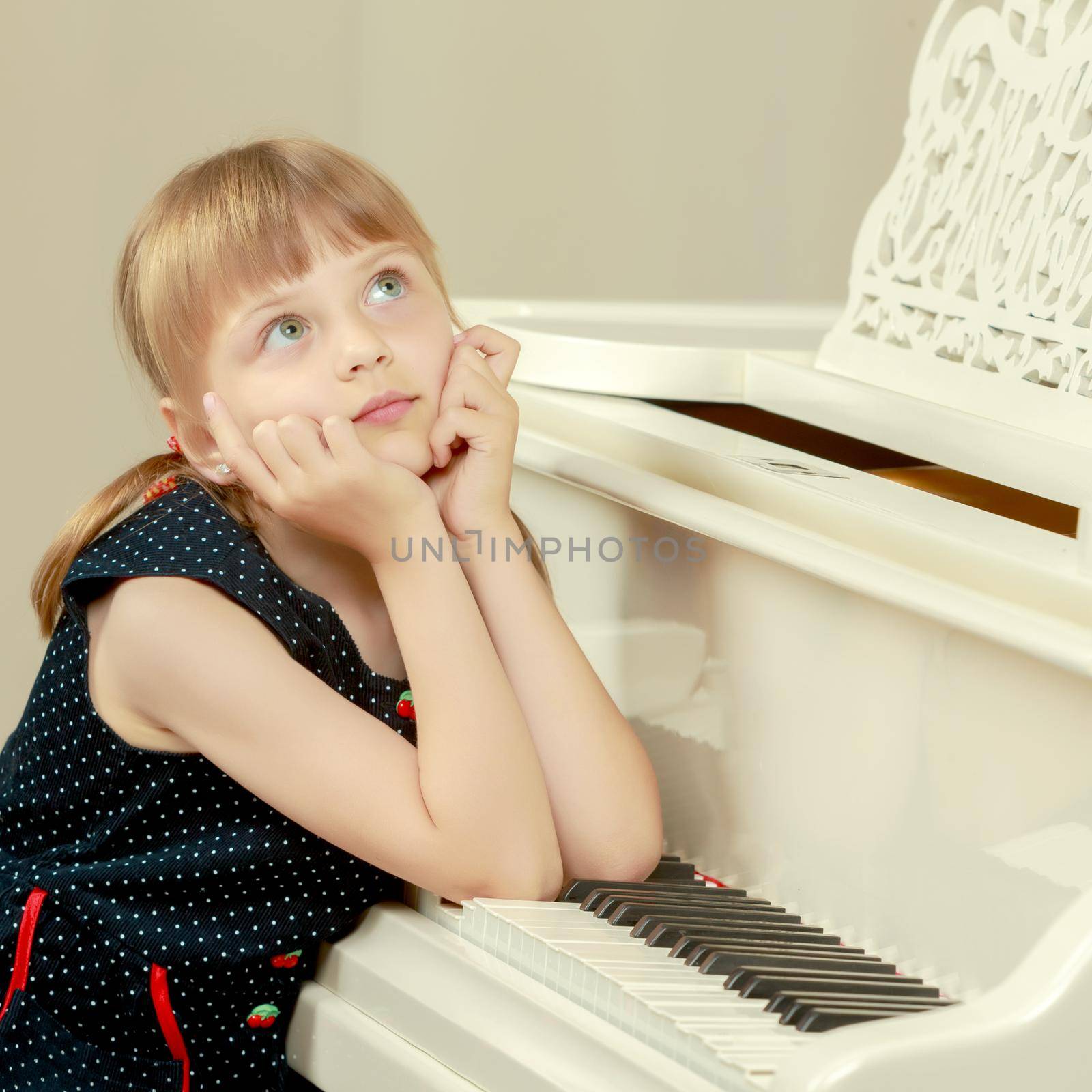 Beautiful little girl is playing on a white grand piano. by kolesnikov_studio