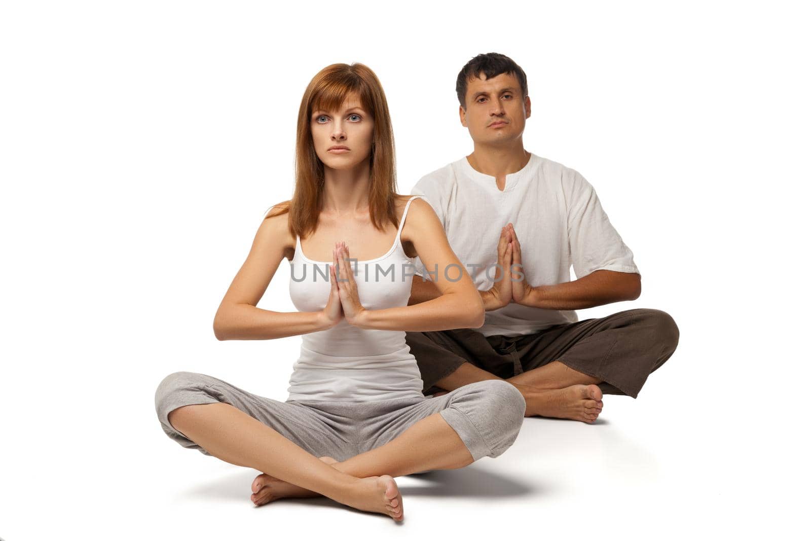 Young healthy couple in yoga position on white background