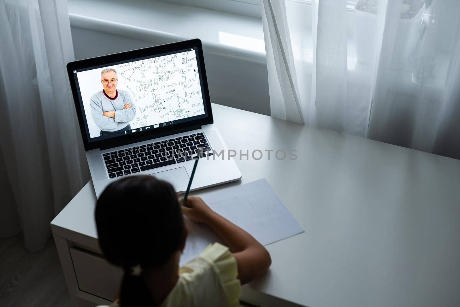home, leisure, technology and internet concept - little student girl with laptop computer at home, little girl uses video chat by Andelov13