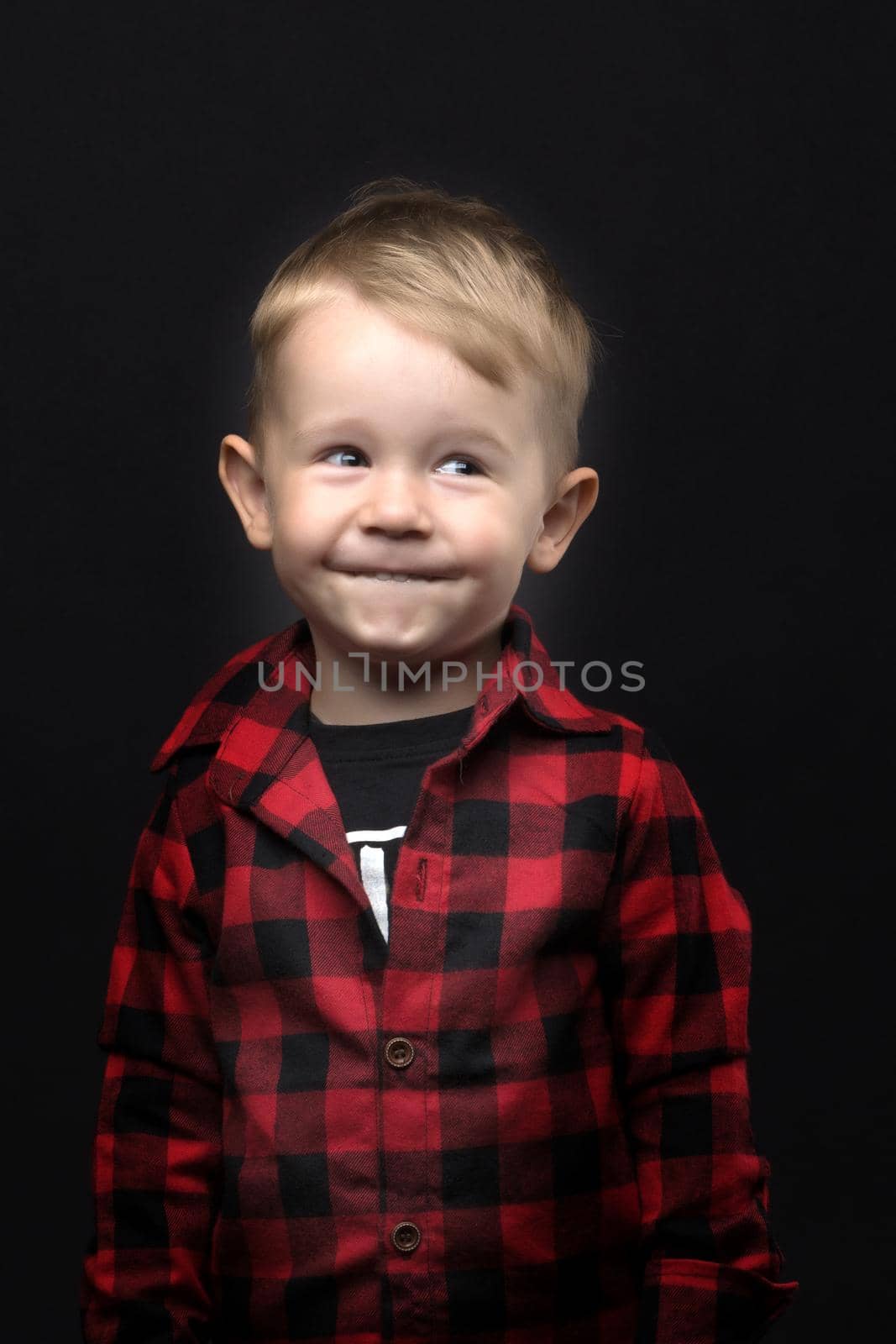 Little boy on a black background. by kolesnikov_studio