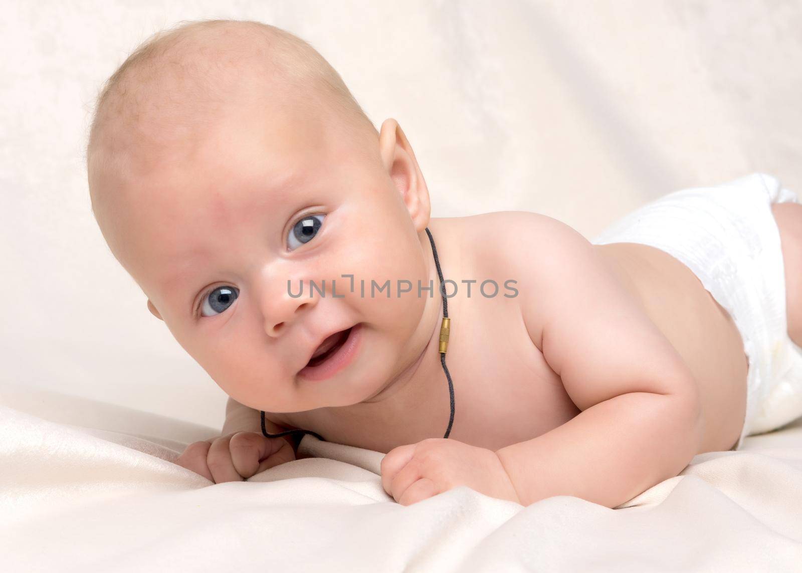 A charming baby looks at the camera. by kolesnikov_studio