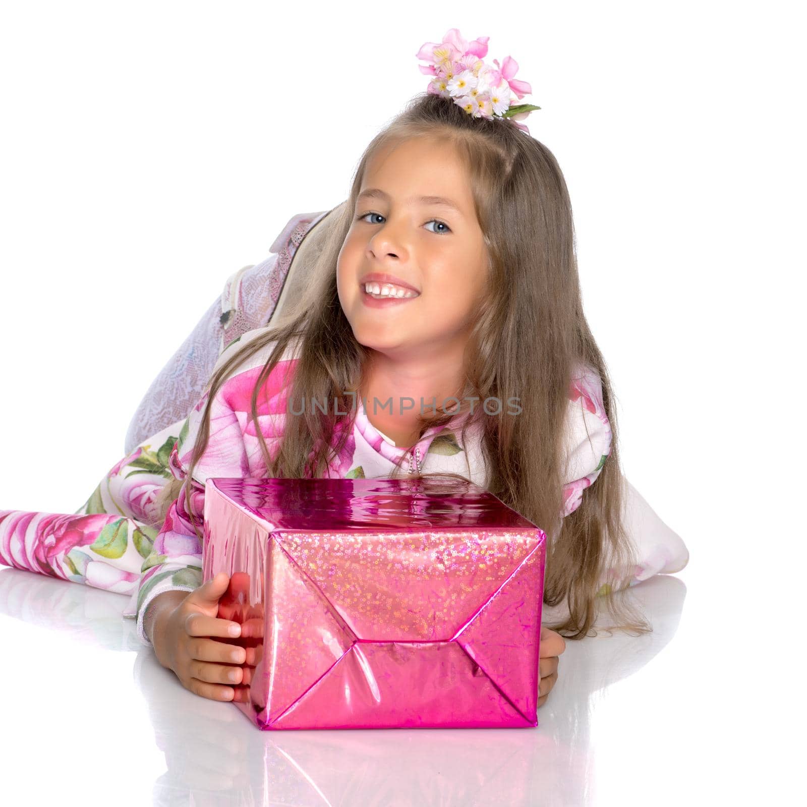 Beautiful little girl with a gift on a white background. Concept of a holiday, New Year and Christmas. Isolated.