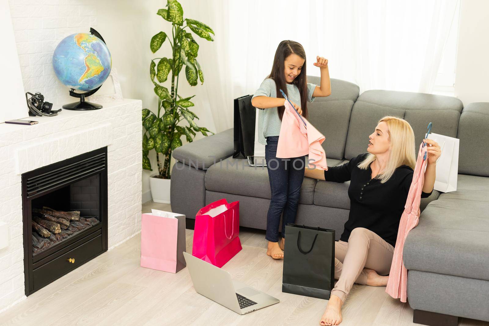 Jolly mother and her daughter having fun at home after shopping