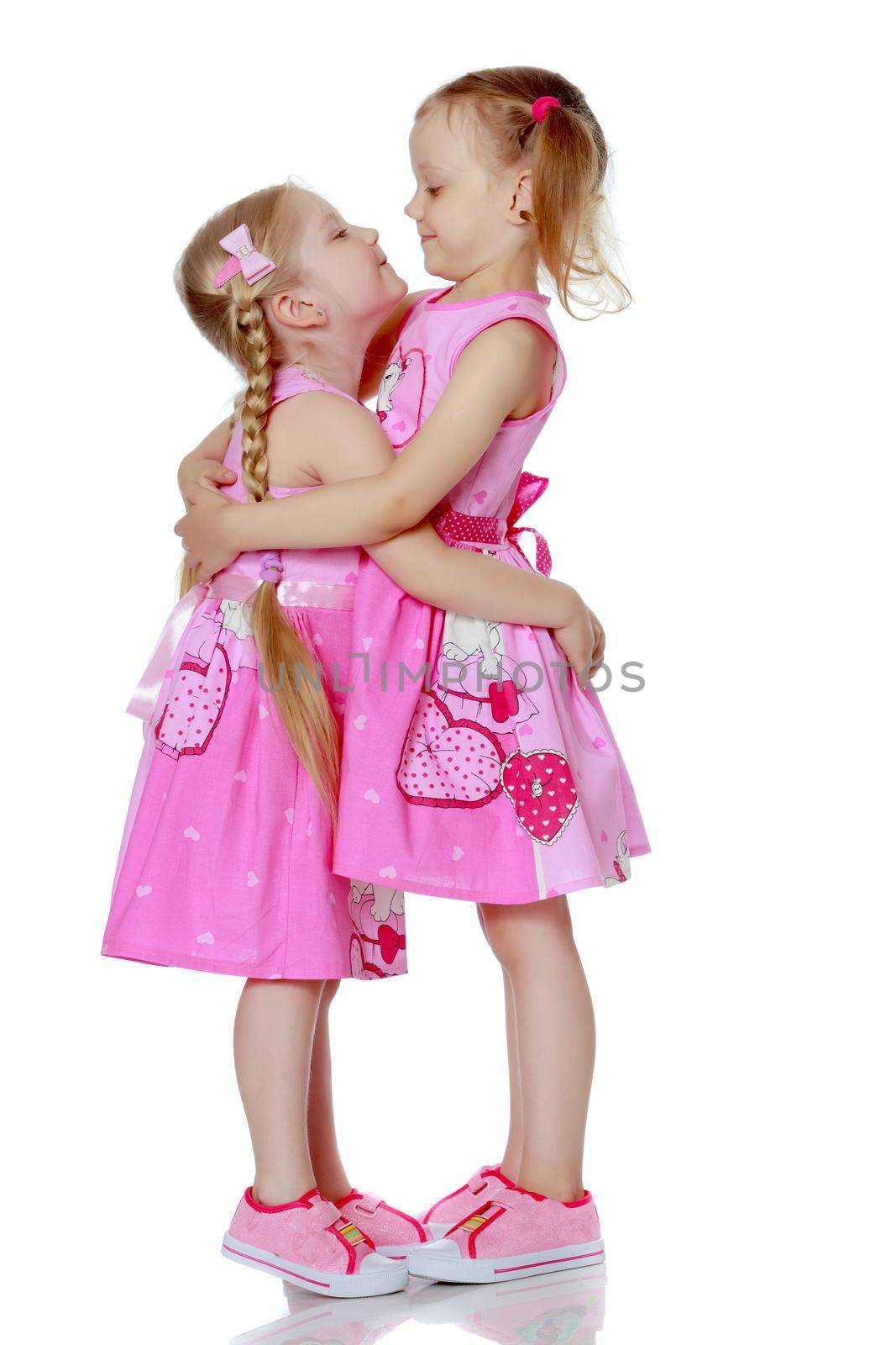 Two cute little girls in full growth, in the studio on a white background. The concept of a happy childhood, Beauty and fashion. Isolated.