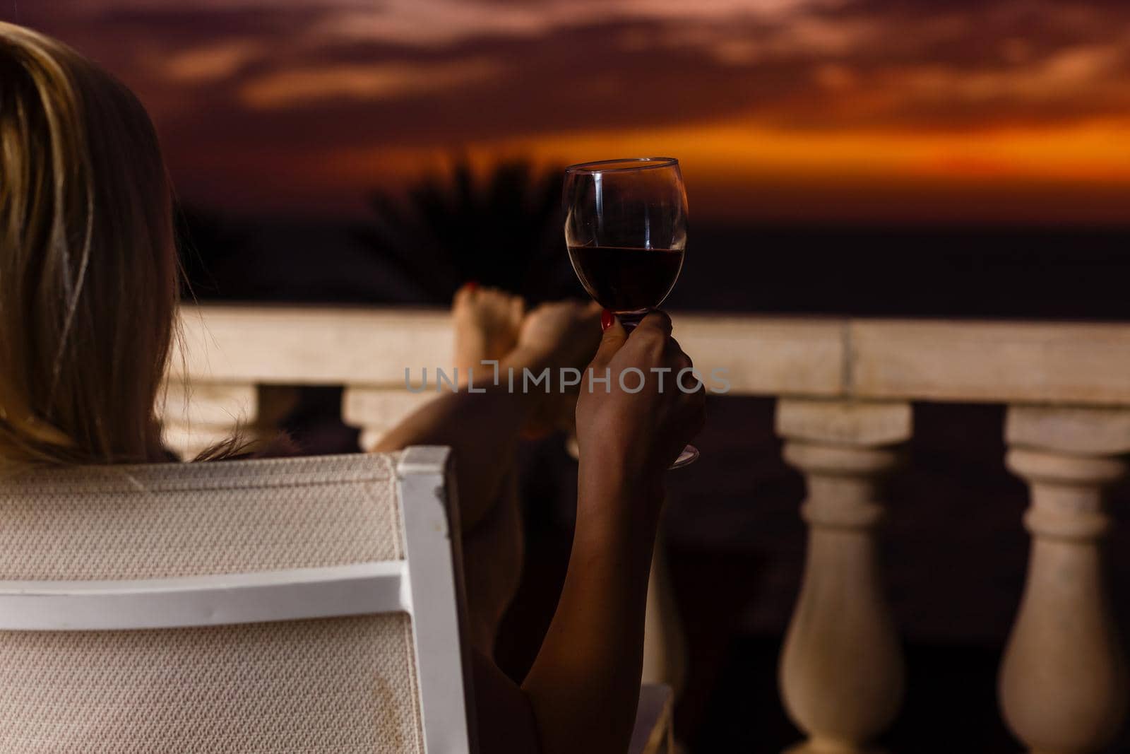 Woman admiring sunset from her balcony