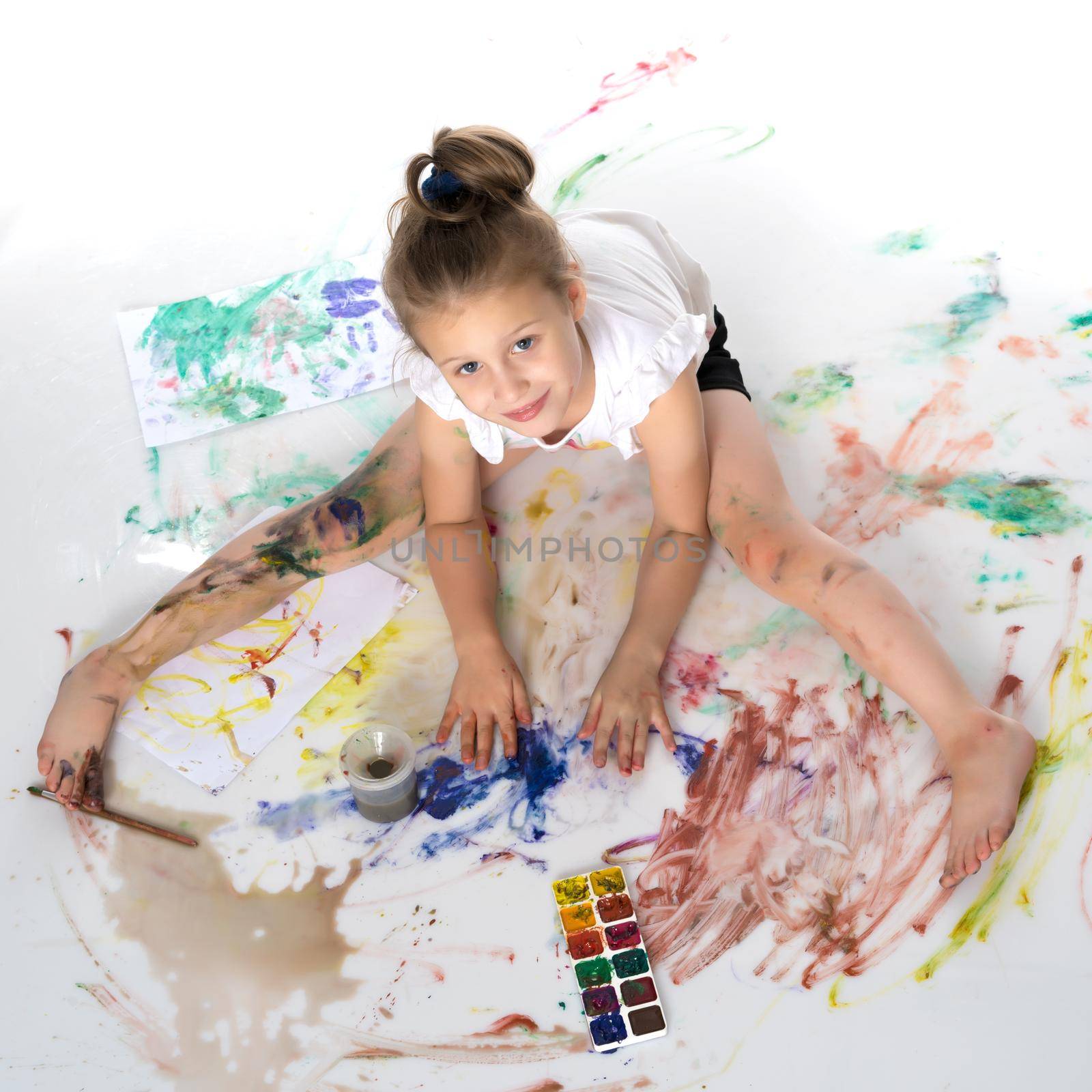 A little girl draws paints on her body. The concept of children's creativity, education and school. Isolated on white background.