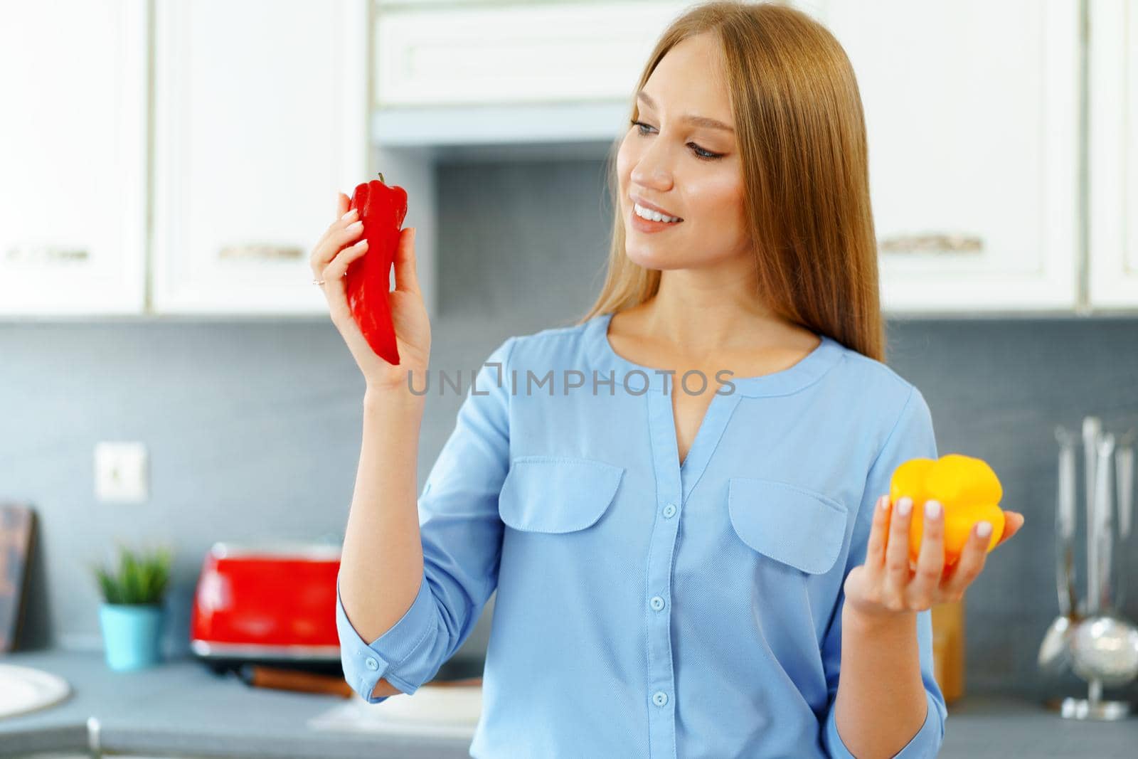 Blonde woman standing in kitchen and cooking close up