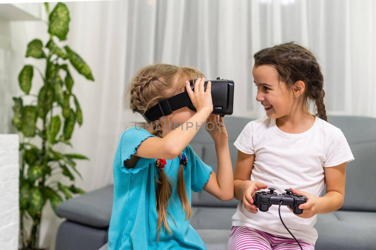 two little girls using glasses of virtual reality headset. concept of modern technologies by Andelov13