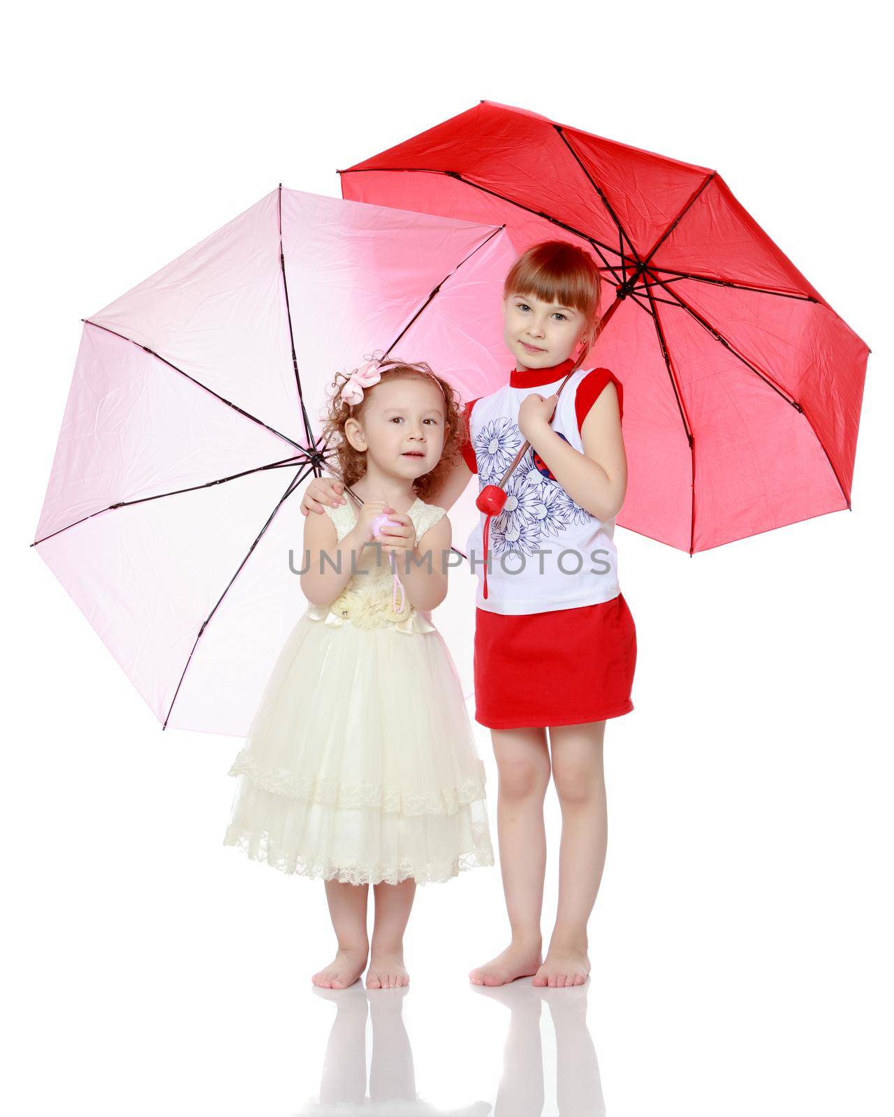 Two charming little girls, little sister and the eldest, sheltered from rain or sun under umbrellas.