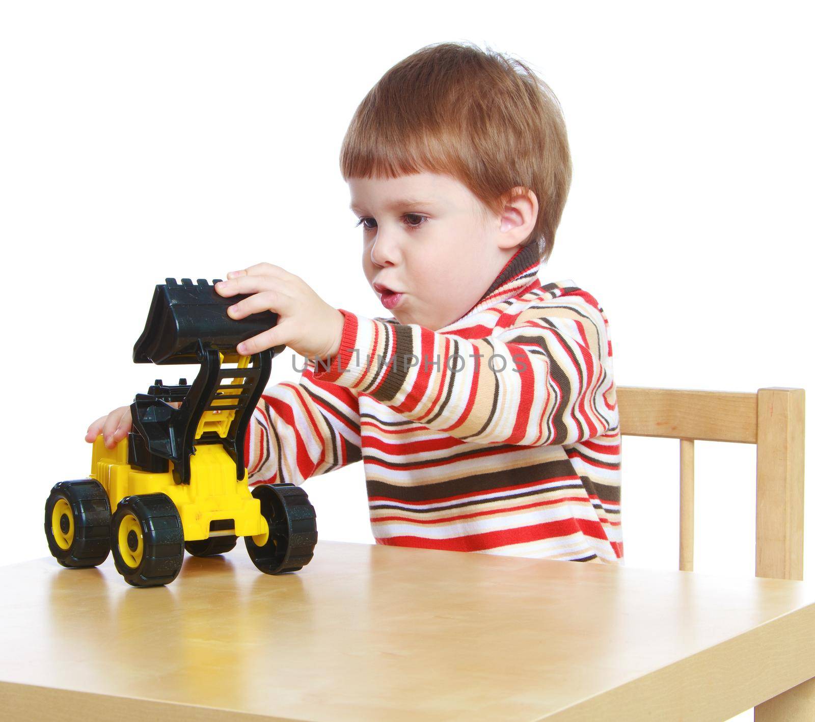 little boy playing with a toy tractor sitting at the table.Isolated on white background portrait.