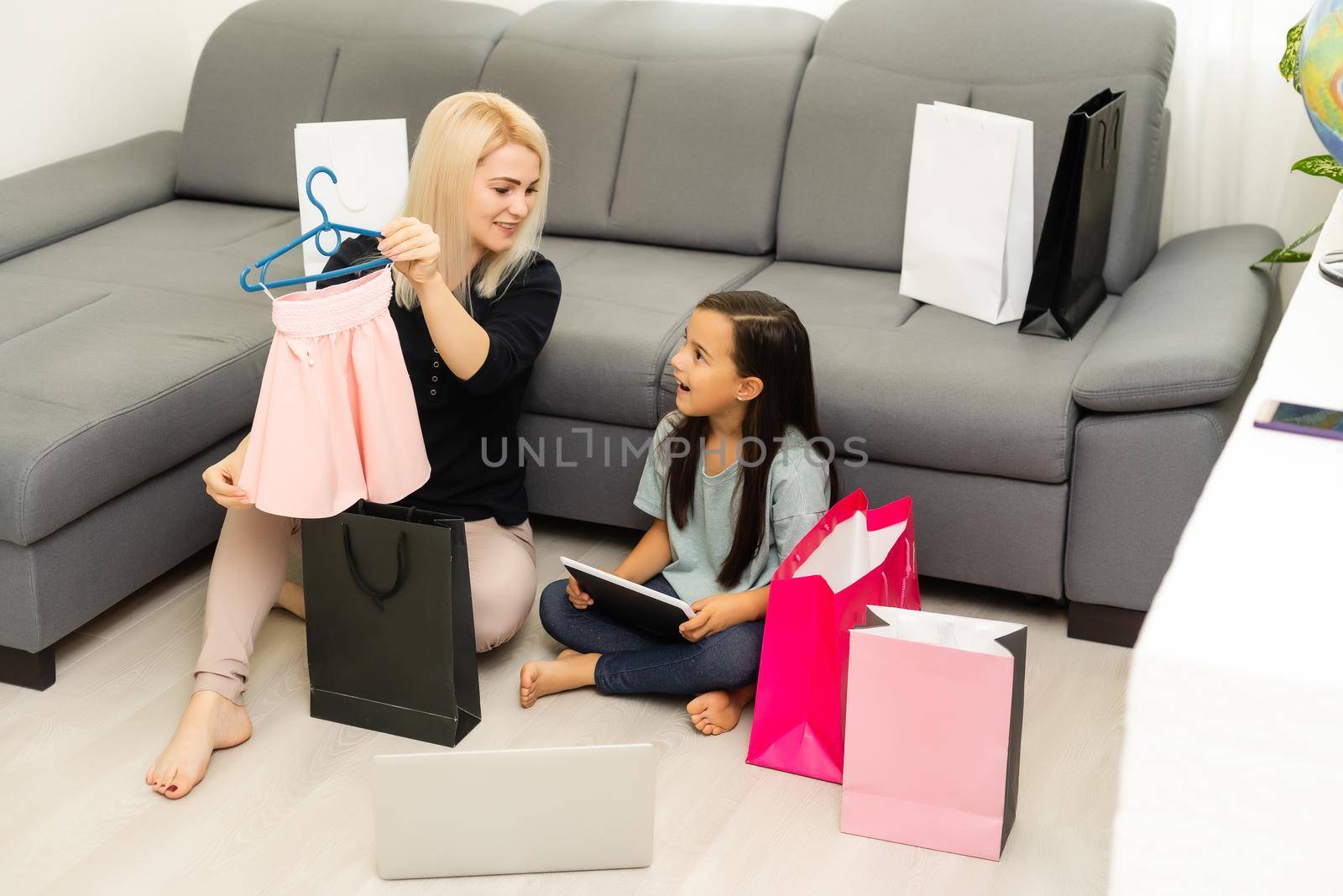 Jolly mother and her daughter having fun at home after shopping