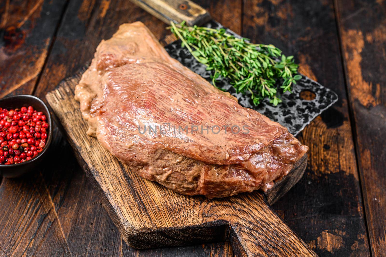 Marinated in mustard Marinate beef tri tip steak for bbq. Black background. Top view.