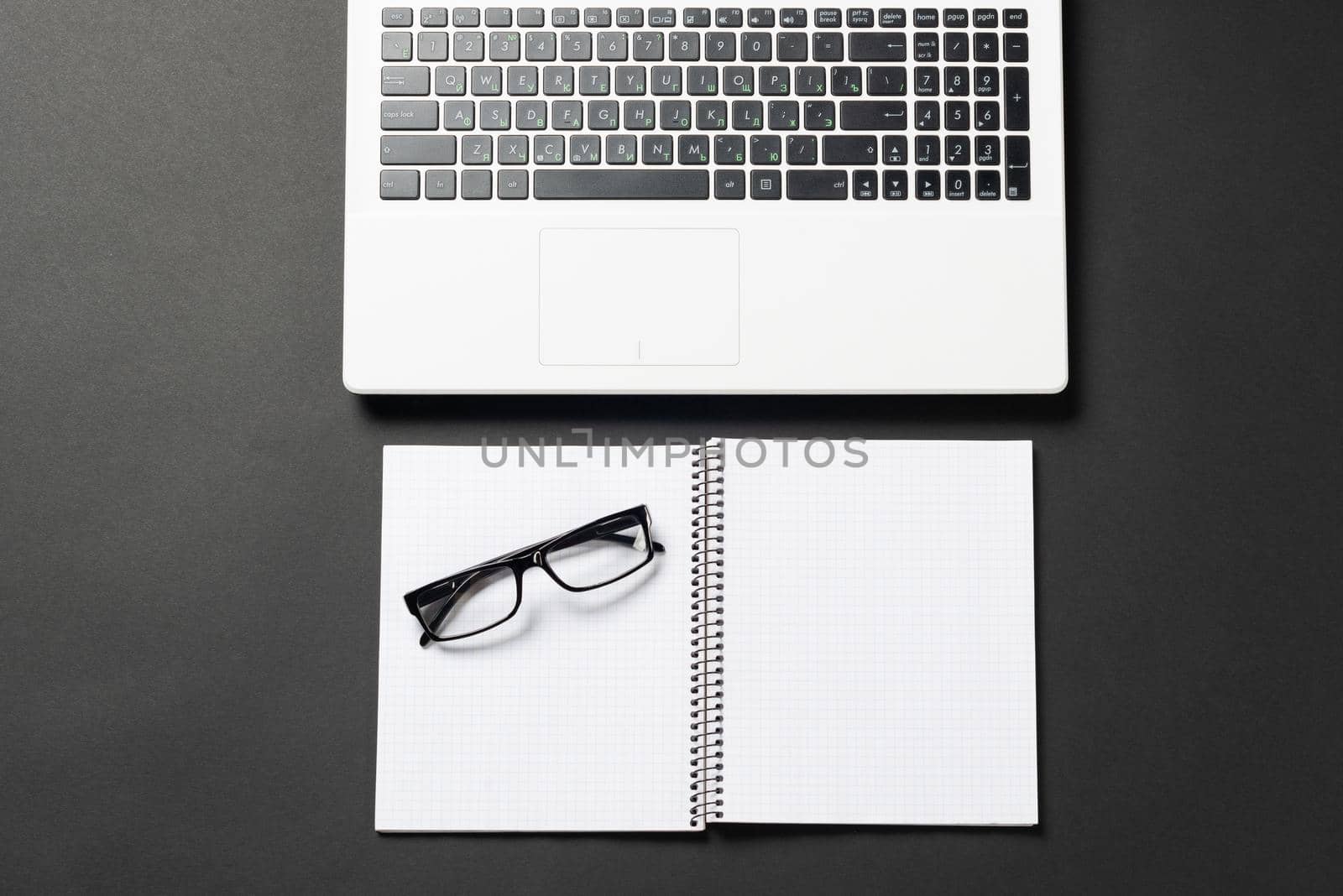 Still life of office workplace with supplies and copy space. Flat lay black surface with laptop computer and open blank notebook. Paperwork, audit and accounting. Top view modern office workspace.