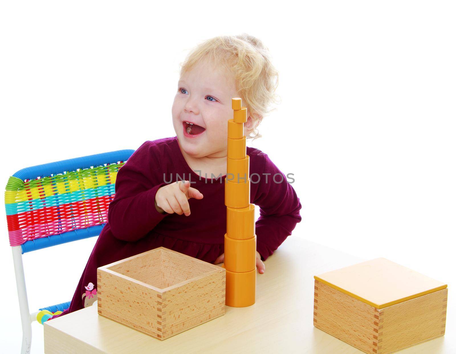 Charming little girl playing at the table