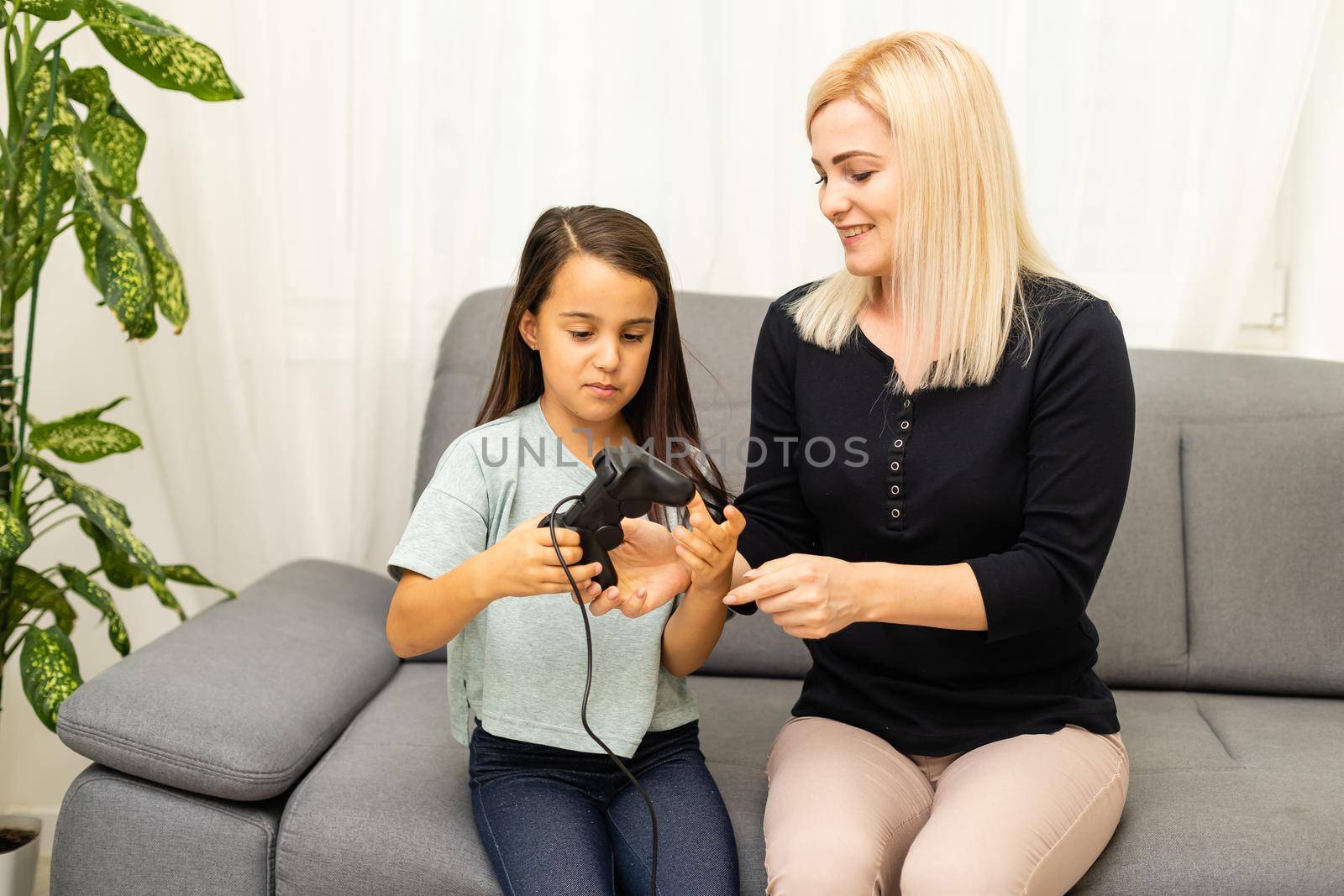 happy family together. mother and her child girl playing video games. family relax.