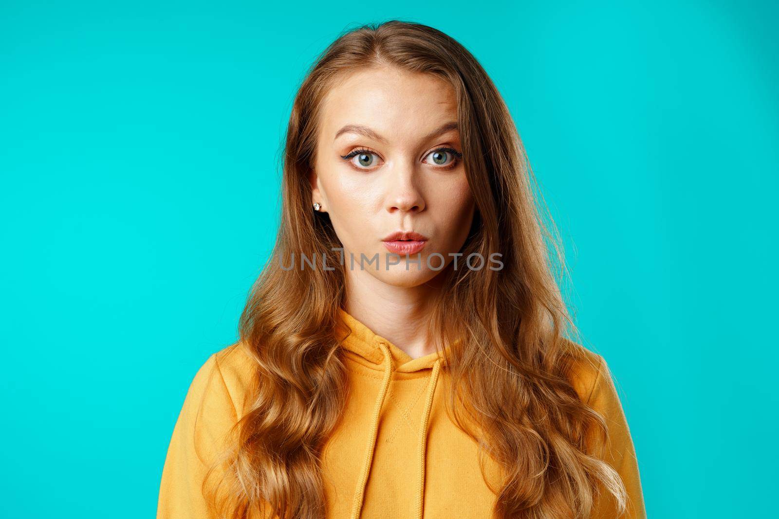 Shocked and amazed young woman with funny face expression close up