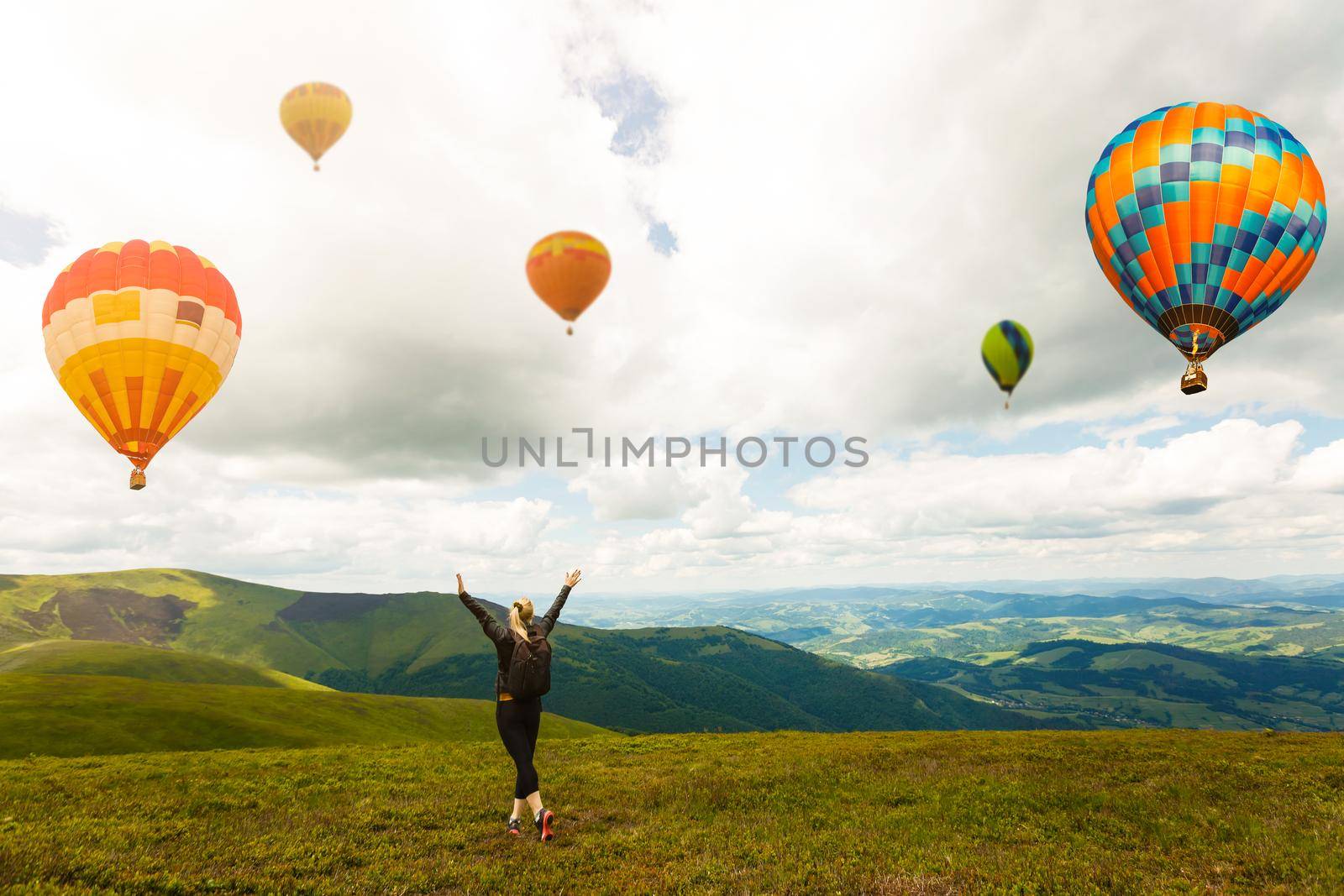 Sunset over forest mountain with hot air balloon.