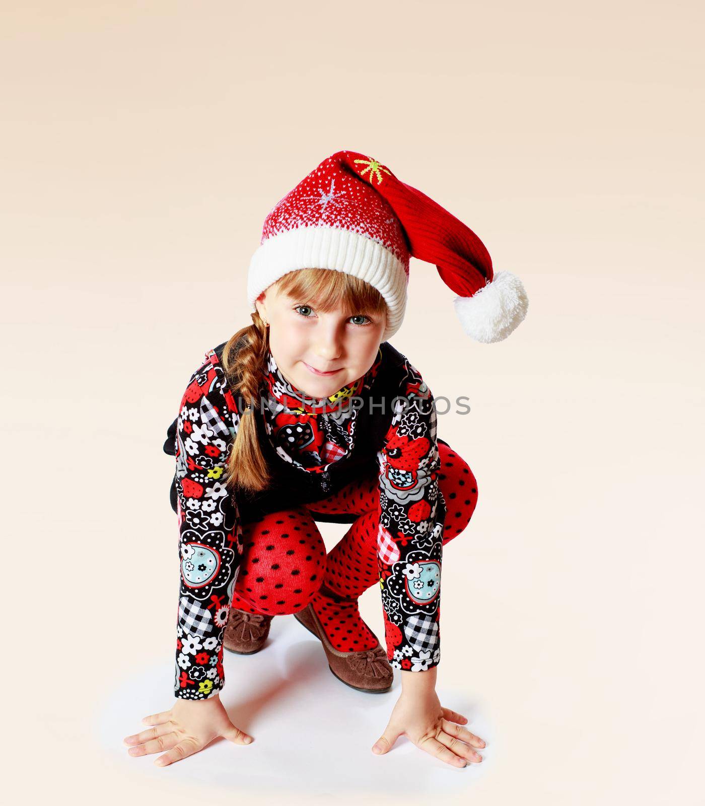 Cheerful little girl in a cap of Santa Claus.