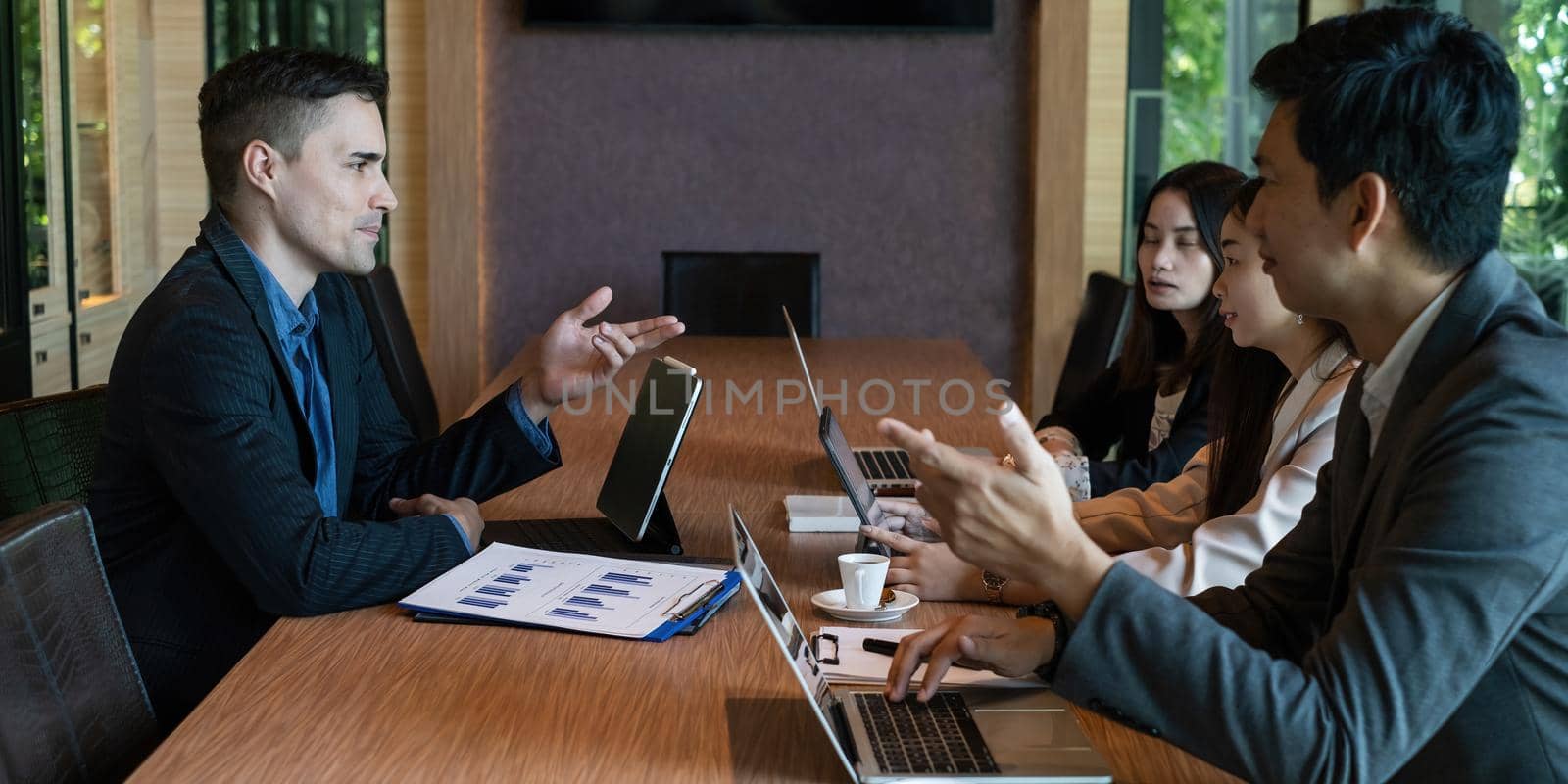 Multiracial business people gather to discuss the company's market plan for the coming year. Teamwork Togetherness Unity Concept. by itchaznong