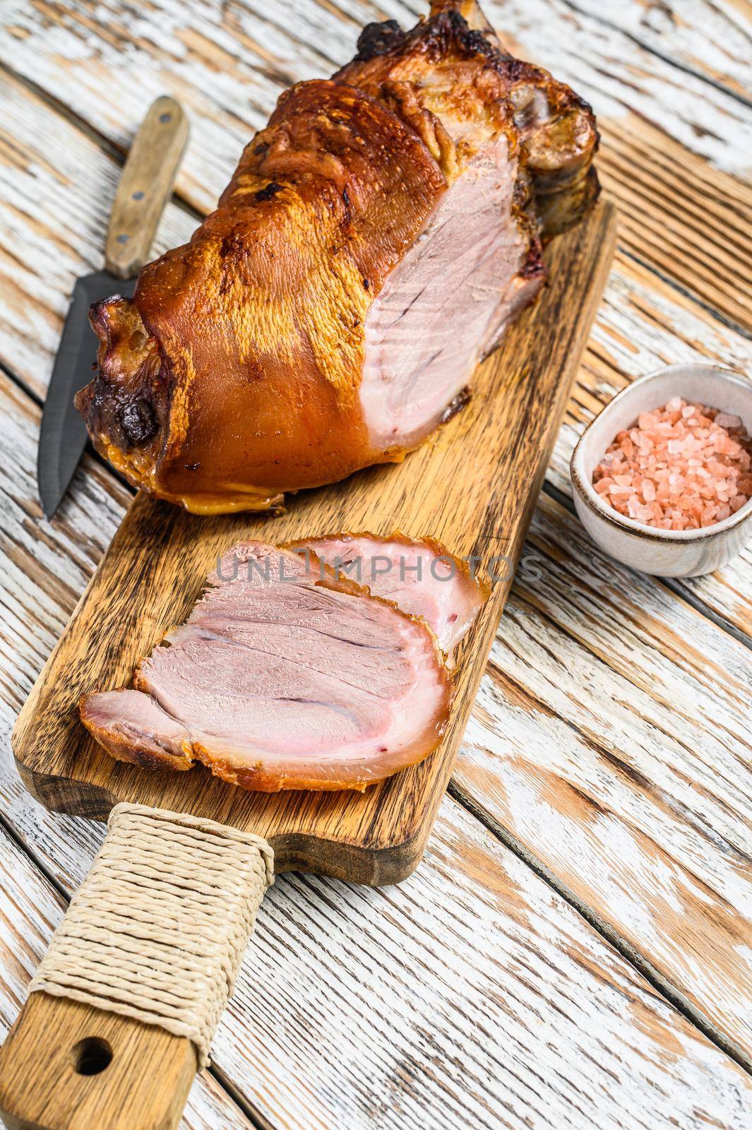 Sliced roasted pork knuckle on a cutting board. wooden background. Top view by Composter