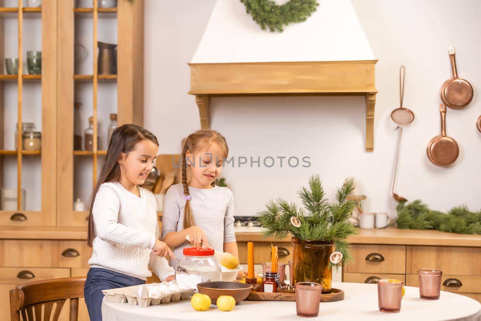 happy sisters children girls two little girls cooking before christmas in the kitchen by Andelov13