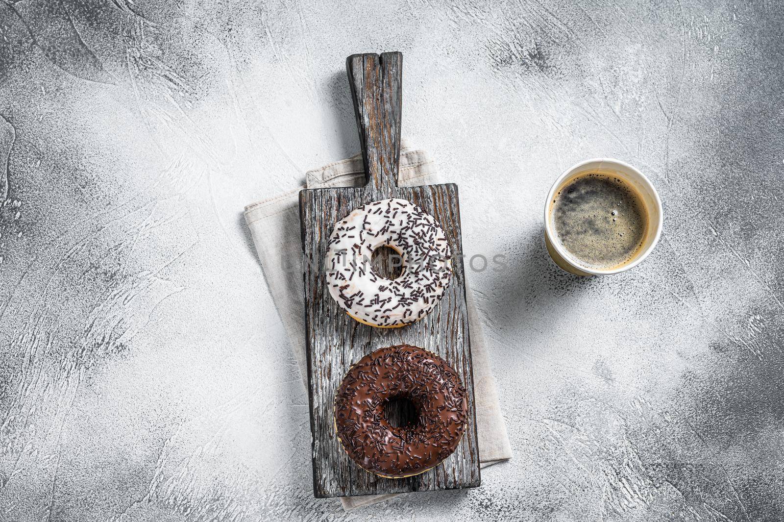 Fresh Chocolate artisan donuts and take away coffee. White background. Top view.