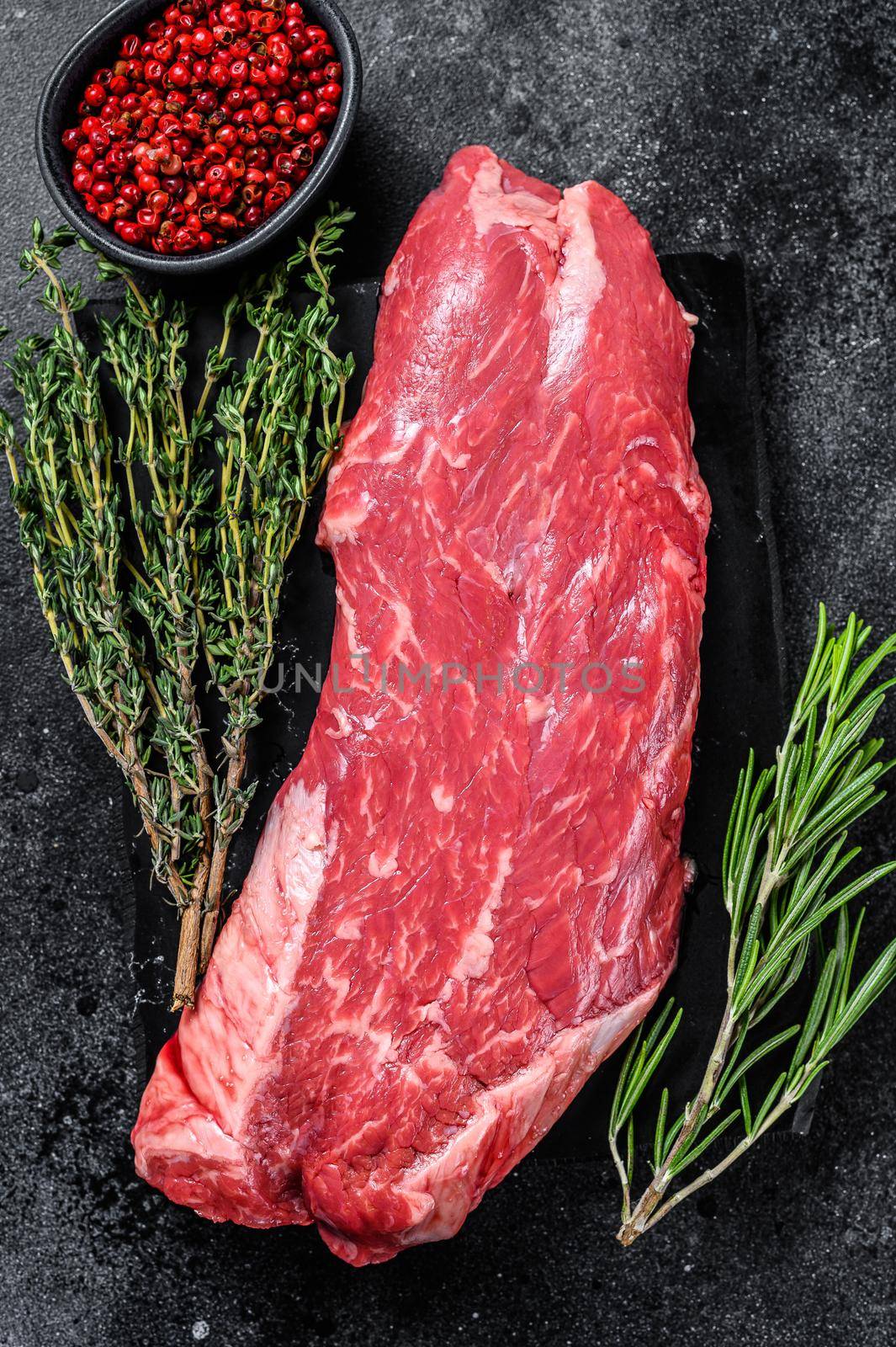 Raw flank beef meat steak. Black background. Top view by Composter