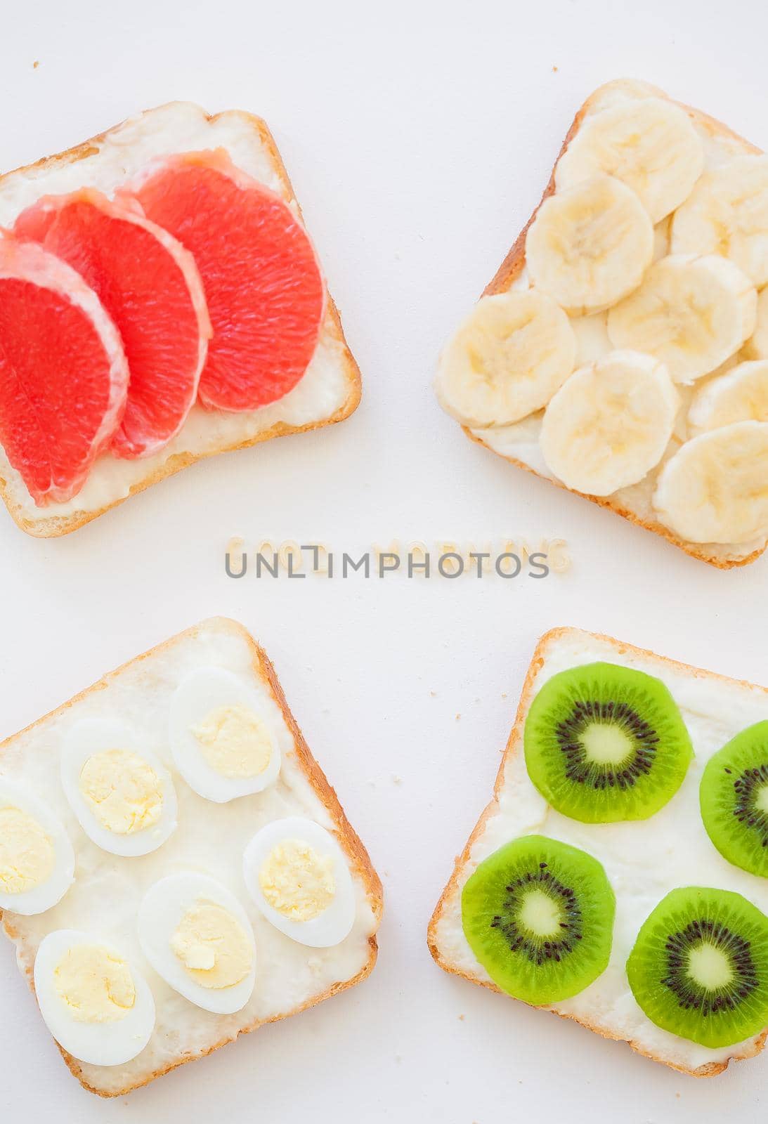 bright mix of sandwiches for breakfast fruit, vegetables, fish, eggs inscription good morning