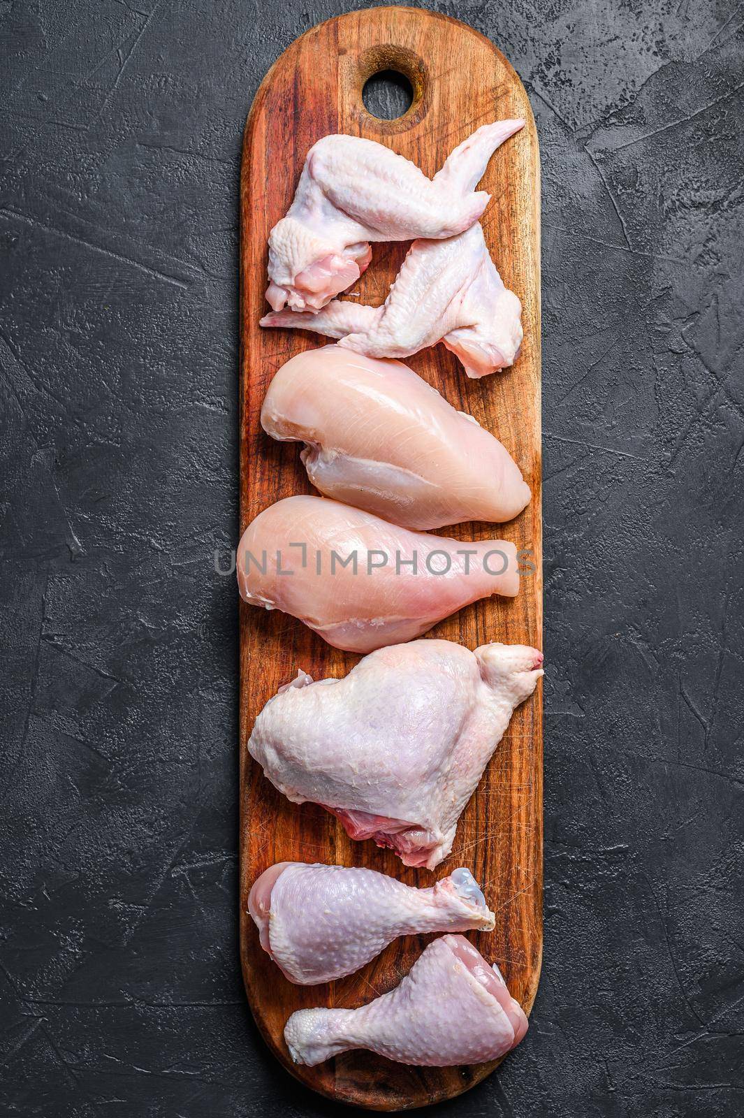 Different types of raw chicken meat, poultry. Black background. Top view by Composter