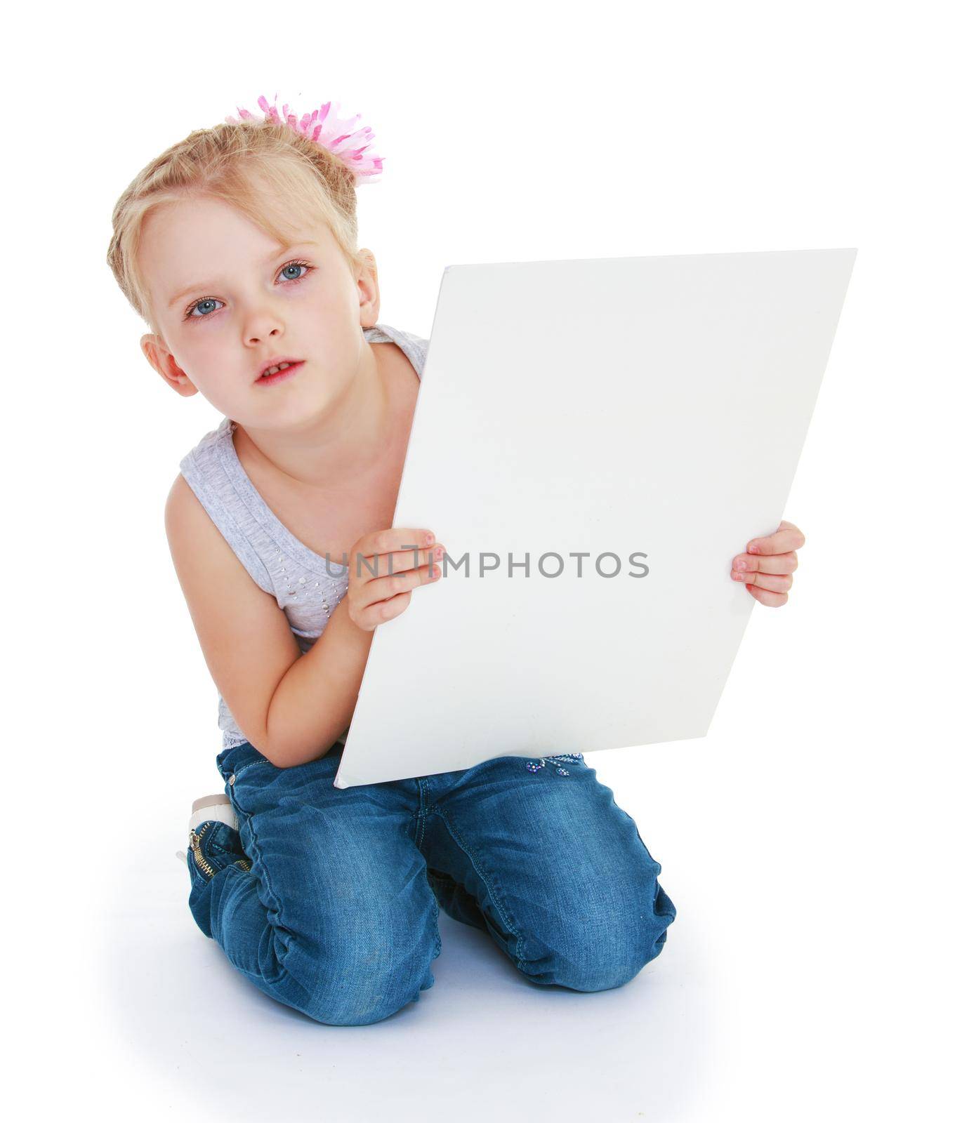 Little girl with a big piece of paper. Isolated on white background .