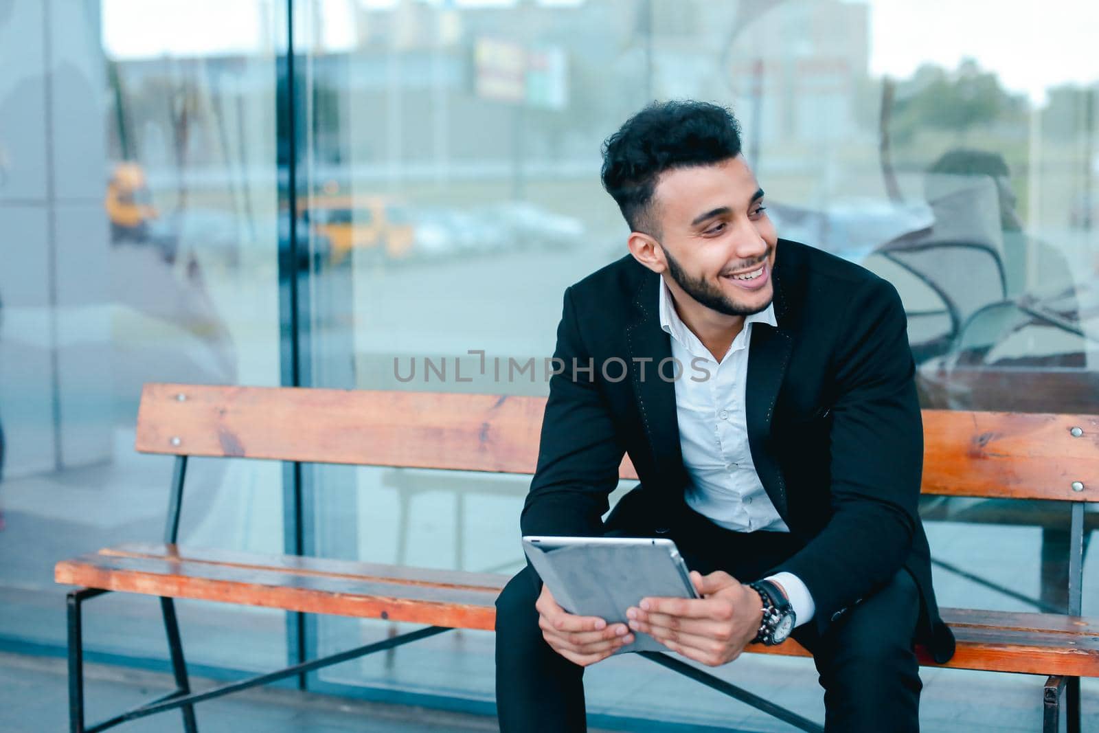 Man in suit arabic puts on sunglasses with tablet near business center by sisterspro